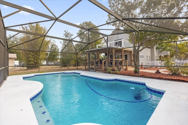 pool featuring glass enclosure, a patio area, and fence