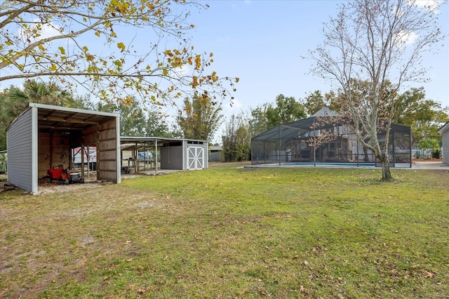 view of yard featuring an outbuilding, a carport, an outdoor structure, and a lanai