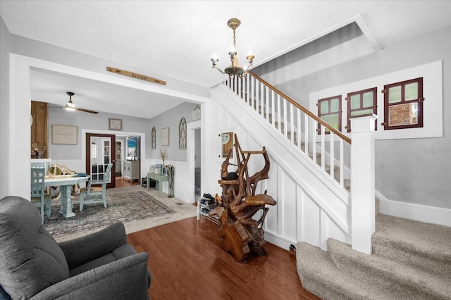 living area with a chandelier, stairway, and wood finished floors