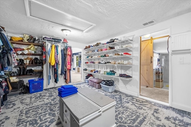 spacious closet featuring attic access, visible vents, and a barn door