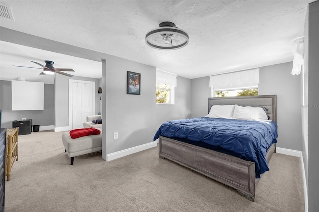 bedroom featuring a textured ceiling, carpet flooring, a ceiling fan, visible vents, and baseboards