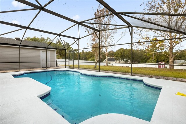 pool with a patio area, glass enclosure, and a lawn