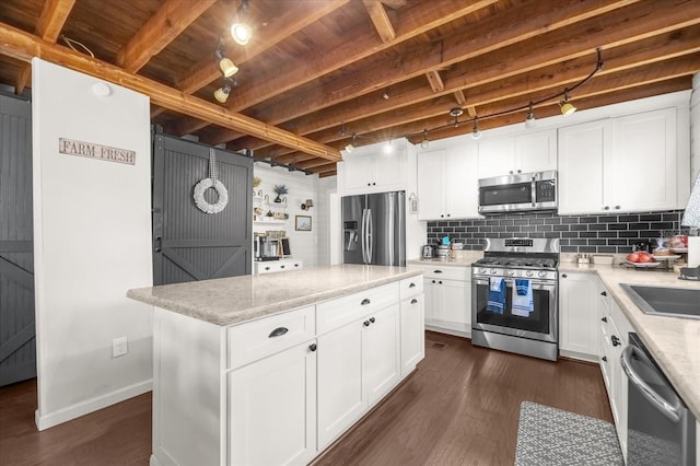 kitchen featuring stainless steel appliances, dark wood-style flooring, white cabinetry, decorative backsplash, and a center island