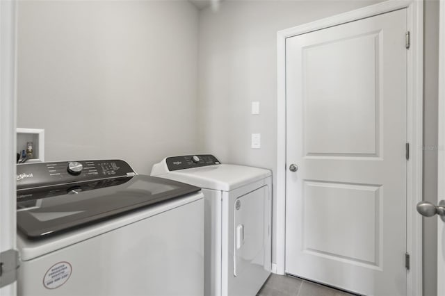 clothes washing area with laundry area, washer and clothes dryer, and tile patterned floors