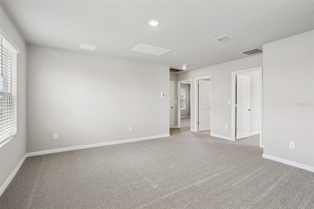 unfurnished room featuring carpet floors, baseboards, and visible vents