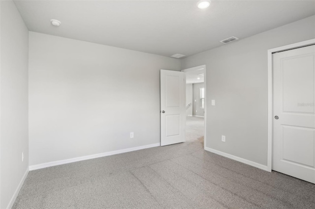 unfurnished bedroom with carpet, visible vents, and baseboards