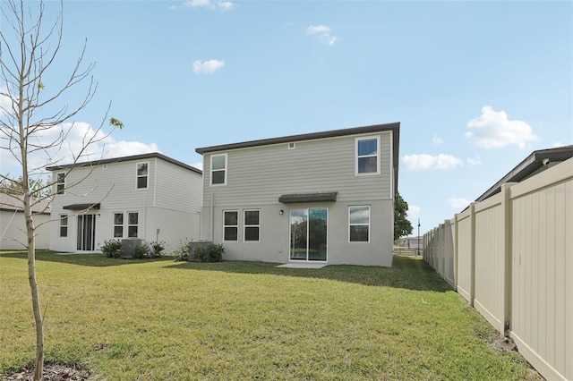 back of house with fence and a lawn