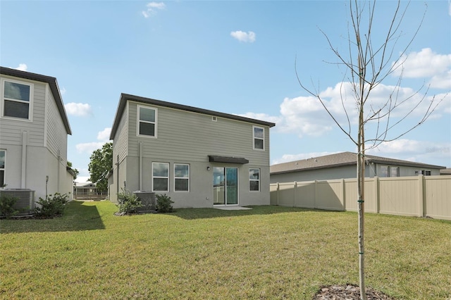 rear view of house with a yard, fence, and central air condition unit