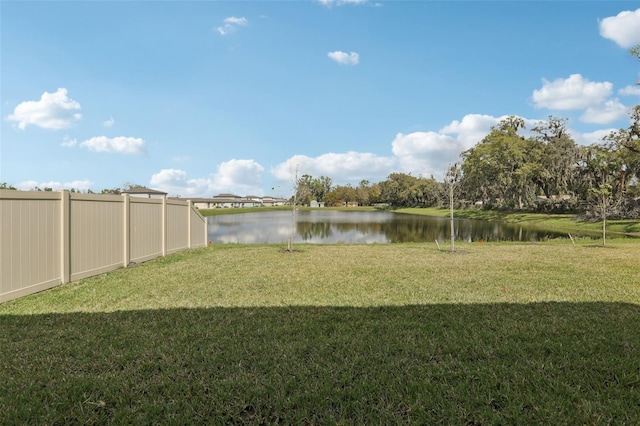 view of yard featuring a water view and fence