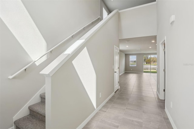 interior space featuring recessed lighting, tile patterned flooring, a high ceiling, and baseboards