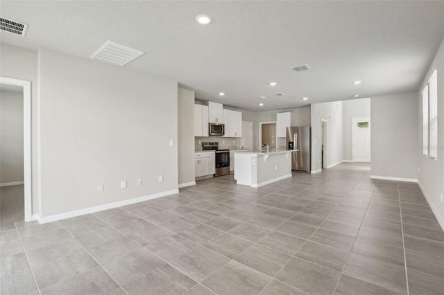 unfurnished living room featuring light tile patterned floors, baseboards, visible vents, and recessed lighting