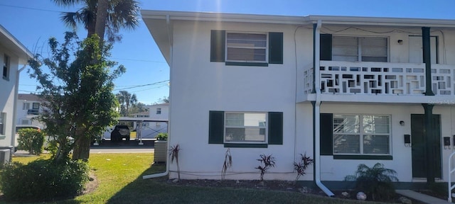 exterior space featuring a balcony and a lawn