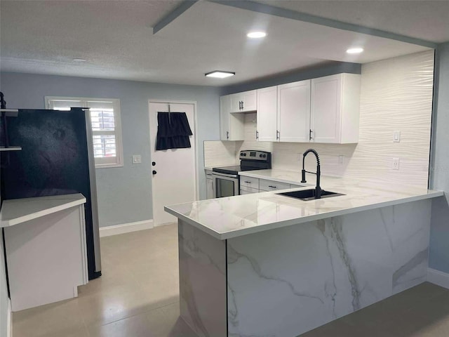 kitchen featuring white cabinetry, stainless steel appliances, sink, backsplash, and kitchen peninsula