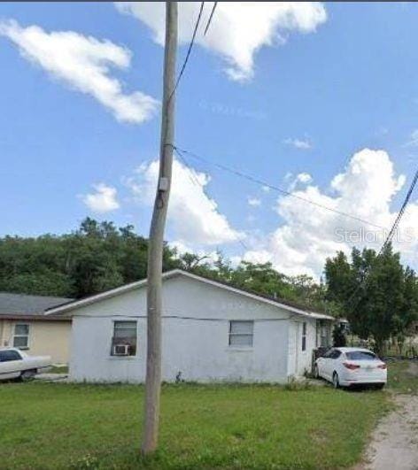 view of side of home featuring a lawn and driveway