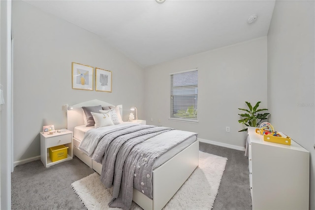 bedroom with lofted ceiling and dark colored carpet