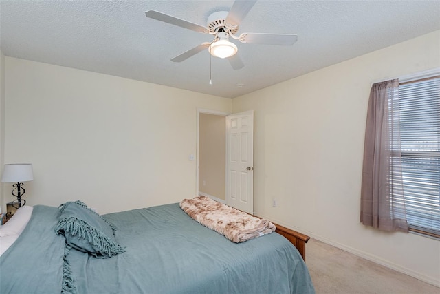 carpeted bedroom with a textured ceiling and ceiling fan