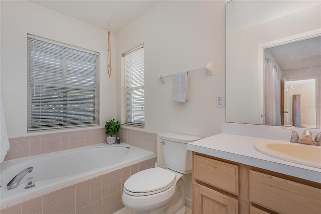 bathroom featuring toilet, vanity, and tiled tub