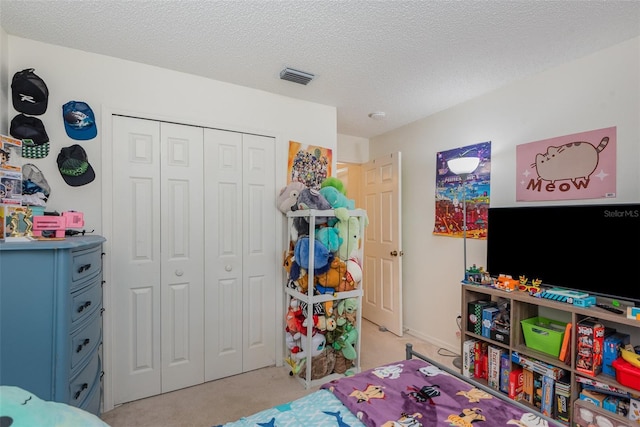 carpeted bedroom featuring a textured ceiling and a closet