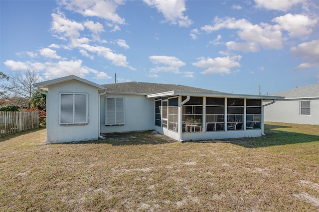 back of house with a sunroom and a yard