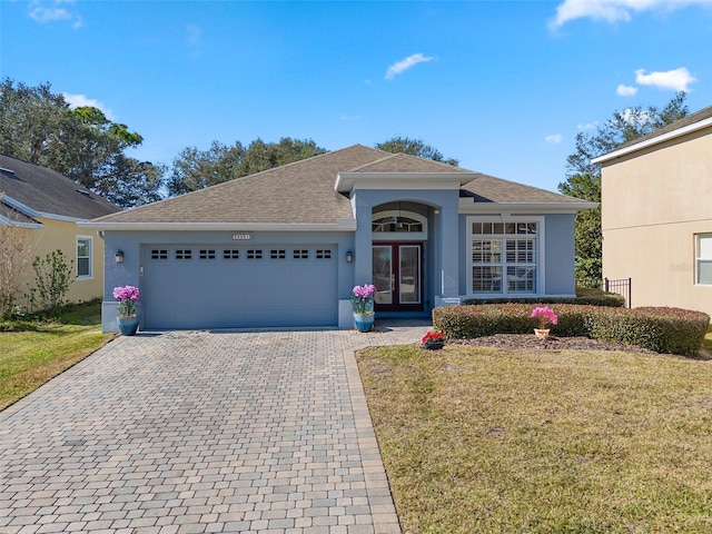 ranch-style home with a garage and a front lawn