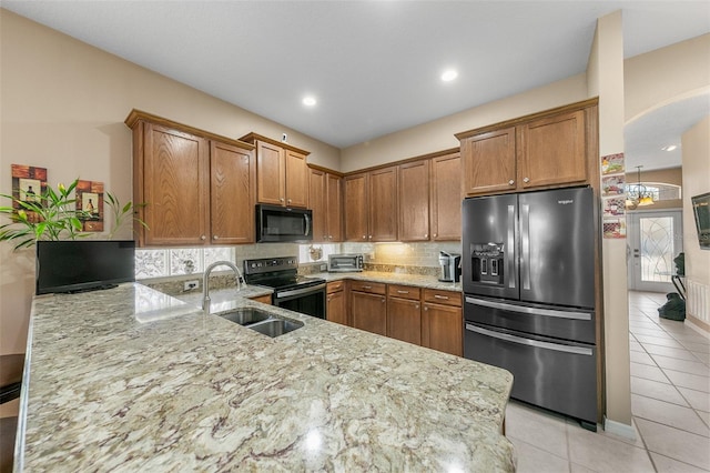 kitchen with light tile patterned flooring, appliances with stainless steel finishes, sink, kitchen peninsula, and light stone countertops