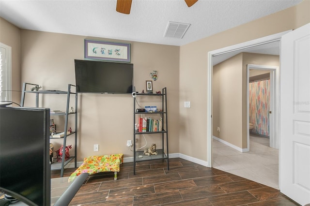 rec room featuring a textured ceiling and ceiling fan