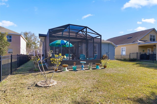 rear view of property featuring a yard and glass enclosure