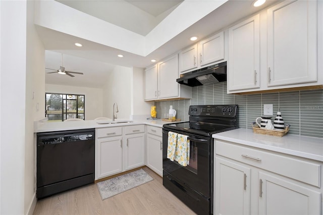 kitchen featuring white cabinets, black appliances, decorative backsplash, sink, and vaulted ceiling