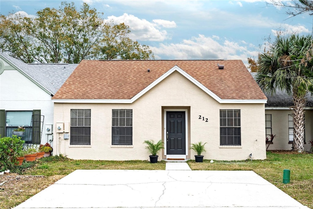 bungalow-style house with a front yard and a patio