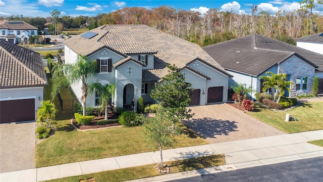 mediterranean / spanish-style home with a front lawn and a garage