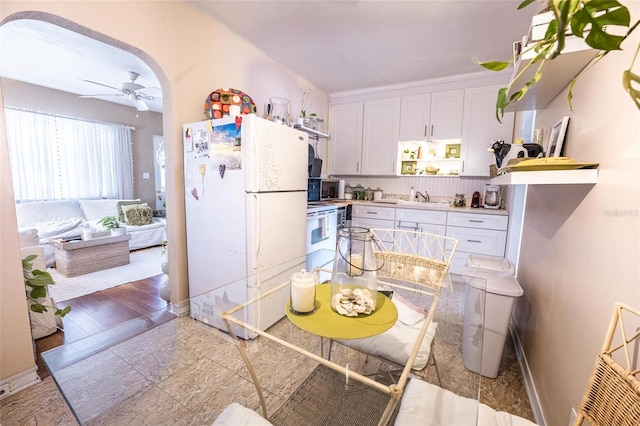 kitchen featuring ceiling fan, white cabinetry, sink, and white appliances