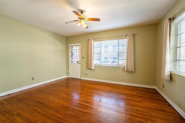 unfurnished room with ceiling fan, a healthy amount of sunlight, and dark hardwood / wood-style flooring