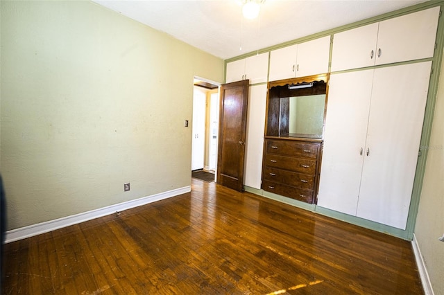 unfurnished bedroom with a closet and dark hardwood / wood-style floors