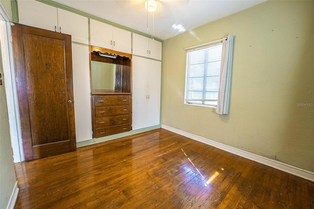 unfurnished bedroom featuring dark wood-type flooring and a closet