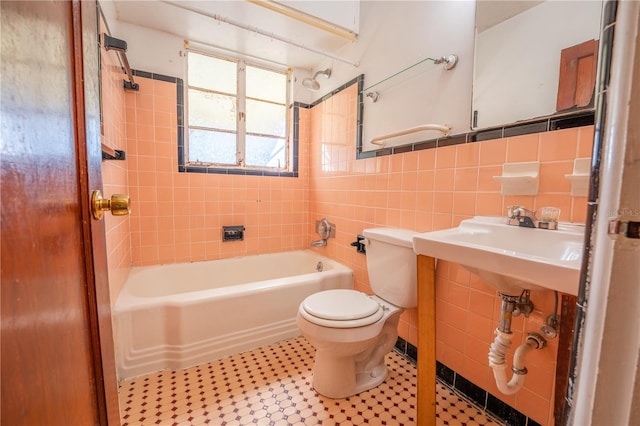 bathroom featuring toilet, tile walls, backsplash, and tiled shower / bath combo