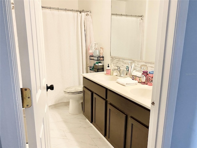 bathroom with vanity, toilet, and decorative backsplash