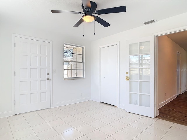 foyer with ceiling fan, visible vents, and baseboards