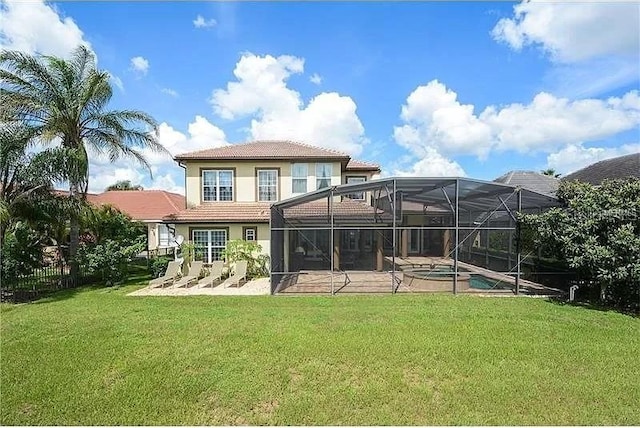 rear view of property featuring a swimming pool with hot tub, a lanai, a yard, and a patio