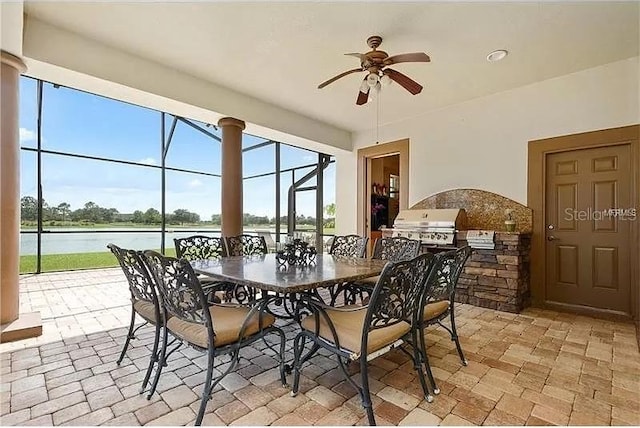 dining space with a water view and ceiling fan