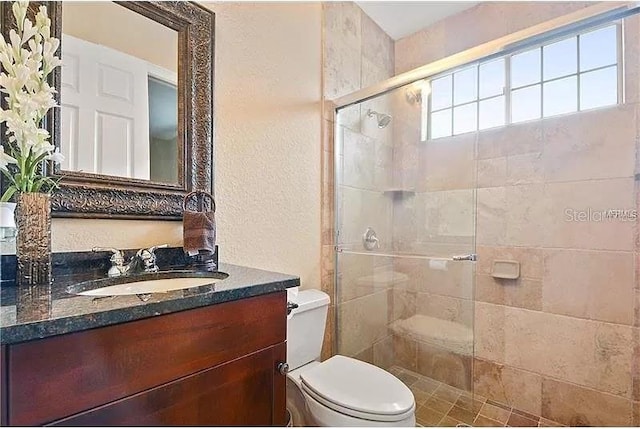 bathroom with toilet, a shower with door, and vanity