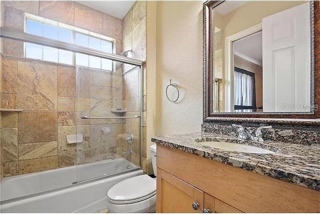 full bathroom featuring toilet, enclosed tub / shower combo, and vanity