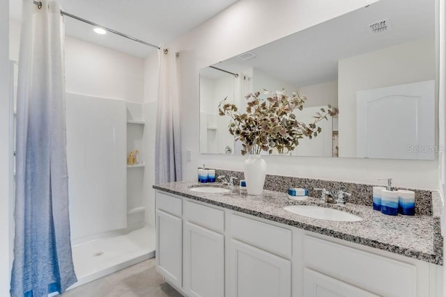 bathroom featuring tile patterned floors, walk in shower, and vanity