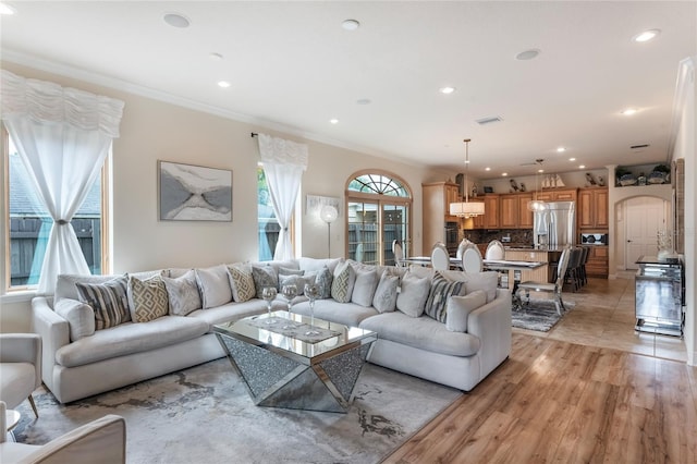 living room featuring ornamental molding and light wood-type flooring