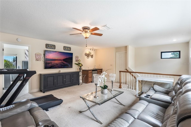 living room with ceiling fan, a textured ceiling, and light carpet