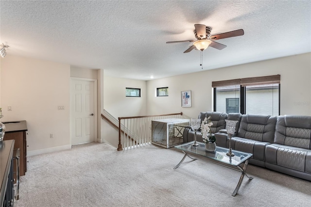 carpeted living room with ceiling fan, a wealth of natural light, and a textured ceiling