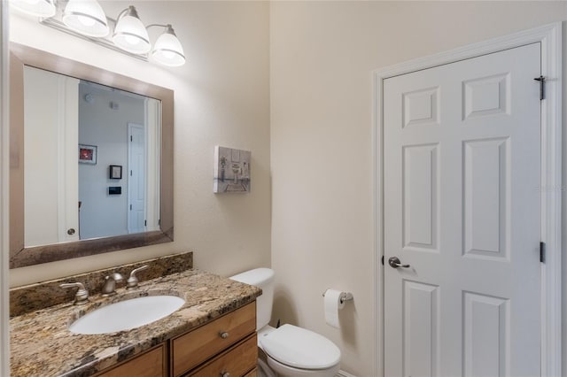 bathroom featuring toilet and vanity