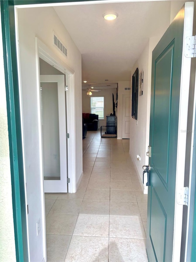 hall featuring light tile patterned floors