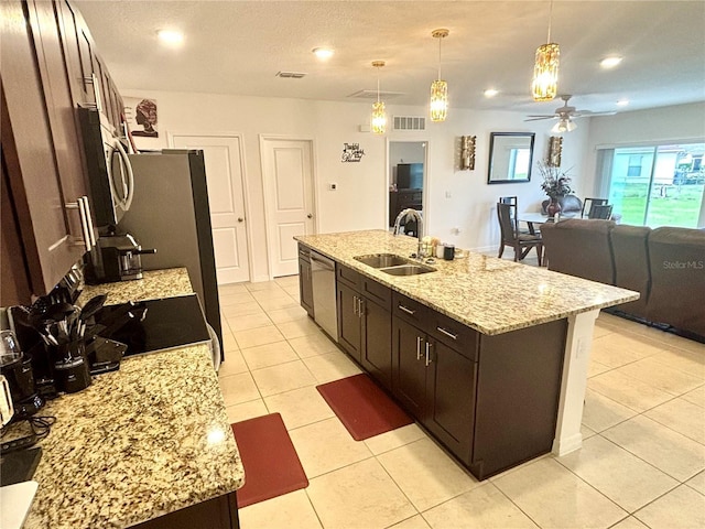 kitchen with ceiling fan, a center island with sink, hanging light fixtures, and sink