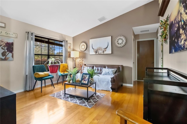 living room featuring lofted ceiling and wood-type flooring