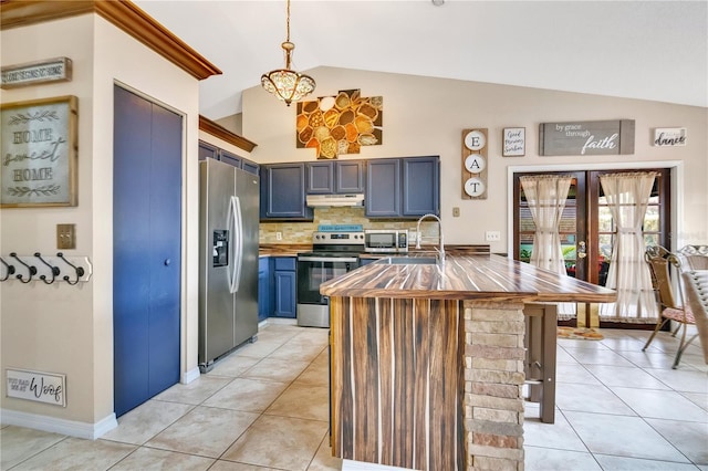 kitchen featuring appliances with stainless steel finishes, decorative backsplash, blue cabinetry, decorative light fixtures, and lofted ceiling